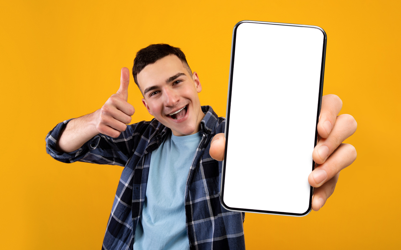 Mobile Application Ad. Excited Young Guy Showing Smartphone with Blank White Screen